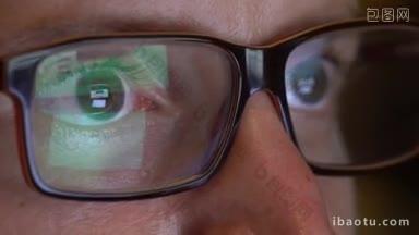特写男子的眼睛在笔记本电脑上工作的眼镜在夜间宏年轻男子戴眼镜上网